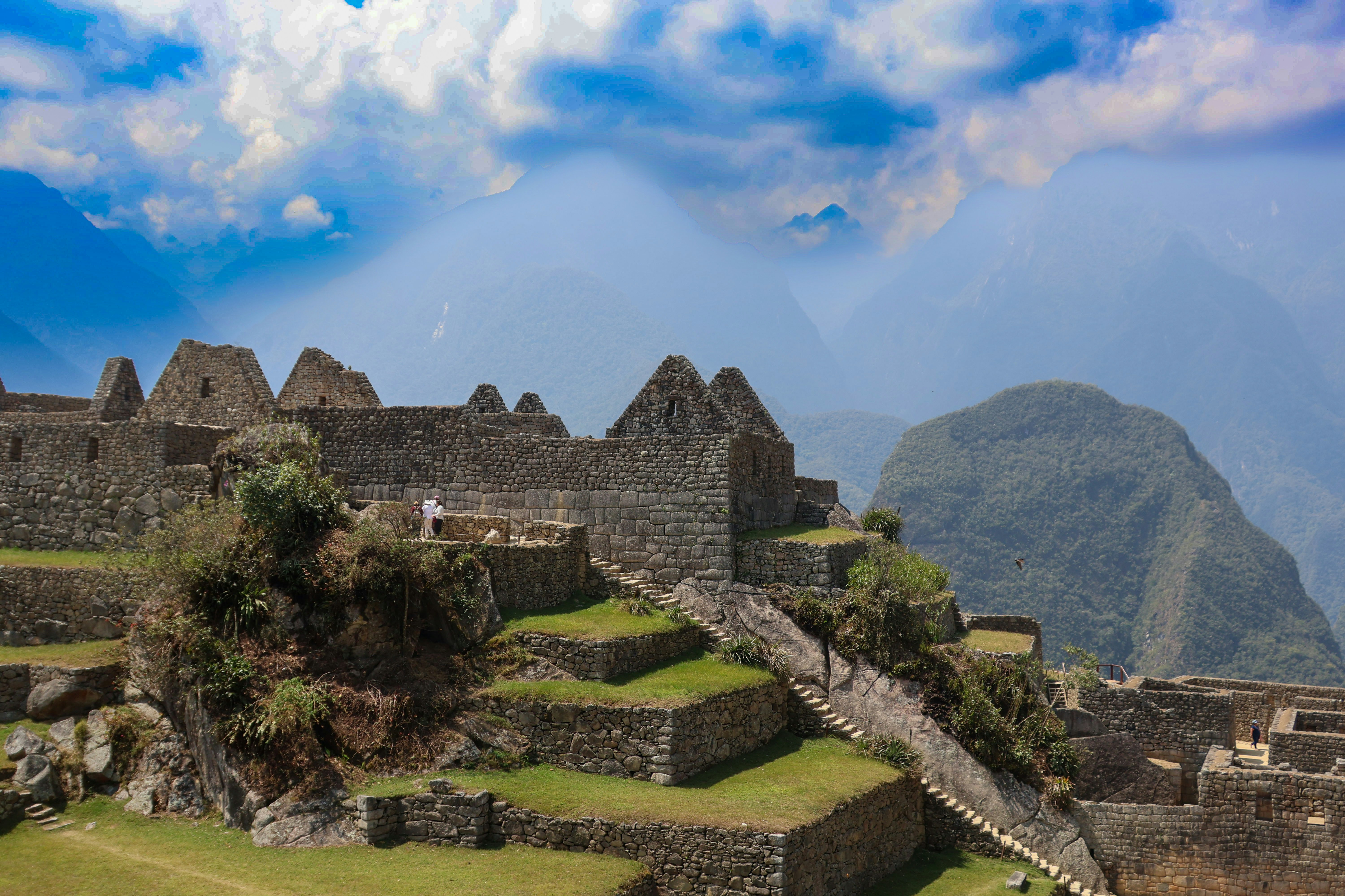 A view of the ruins of a city with a mountain in the background during daytime.